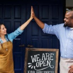Photo of two small business owners exchanging a high five