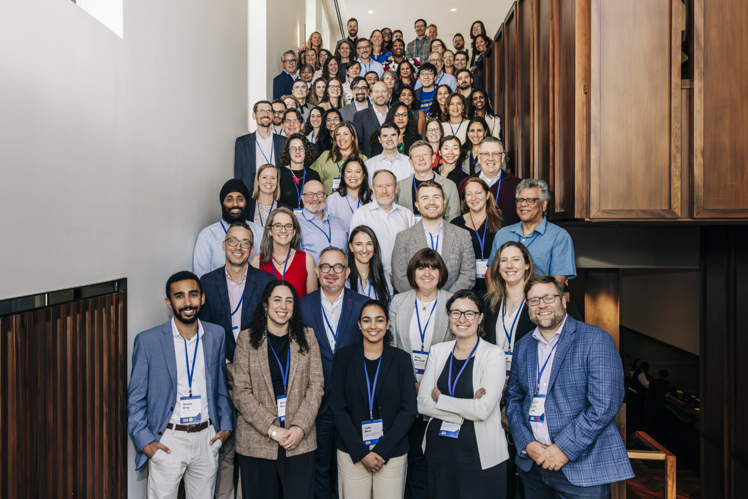 Group of 60+ leaders stand on stairs 