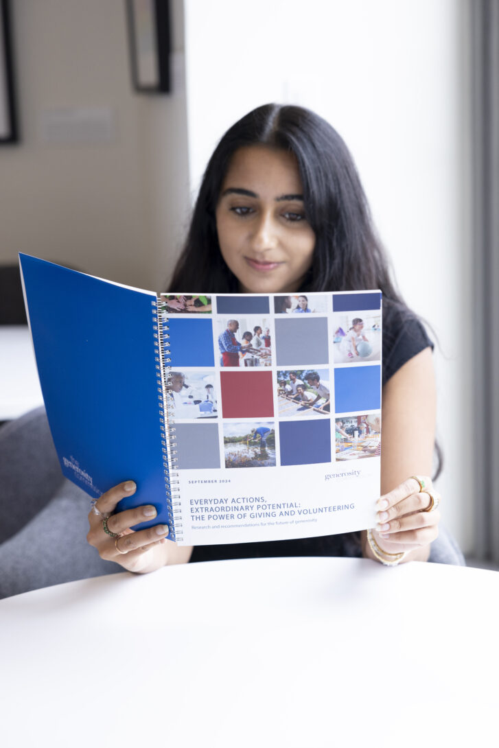A woman reads a copy of The Generosity Commission's capstone report, Everyday Actions, Extraordinary Potential.