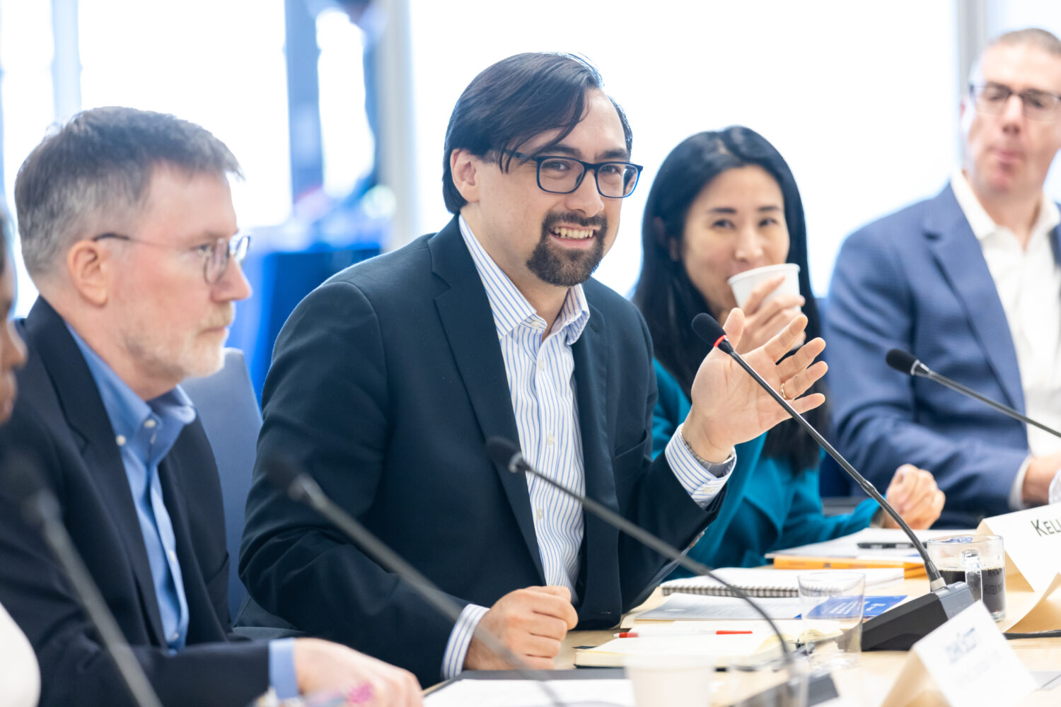 Three people speak on a panel at an event.