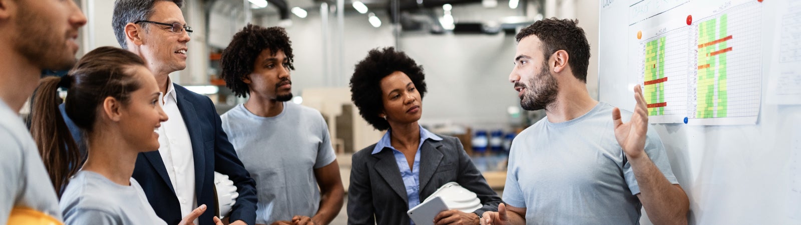 A factory worker presents a new business strategy to his managers and colleagues.