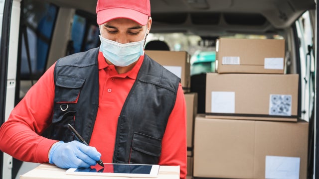 Photo of a delivery worker wearing a face mask and gloves