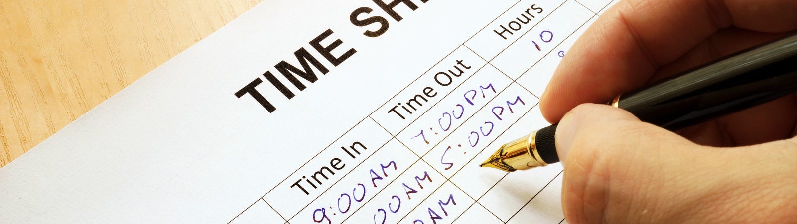Employee writes hours on a time sheet