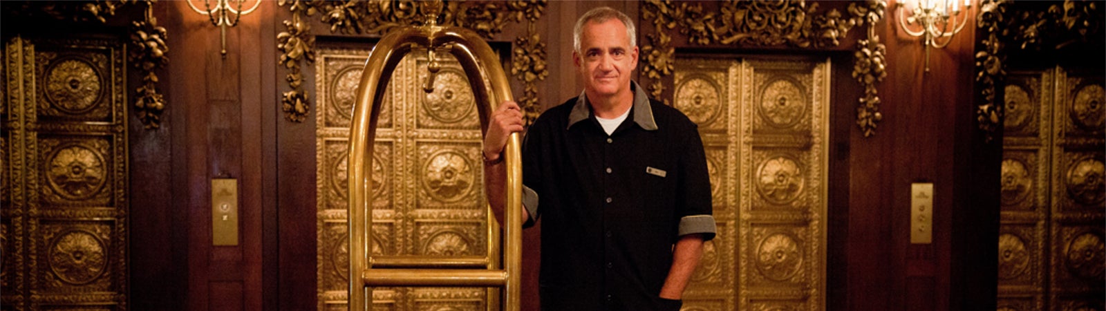 Hotel worker holding luggage cart