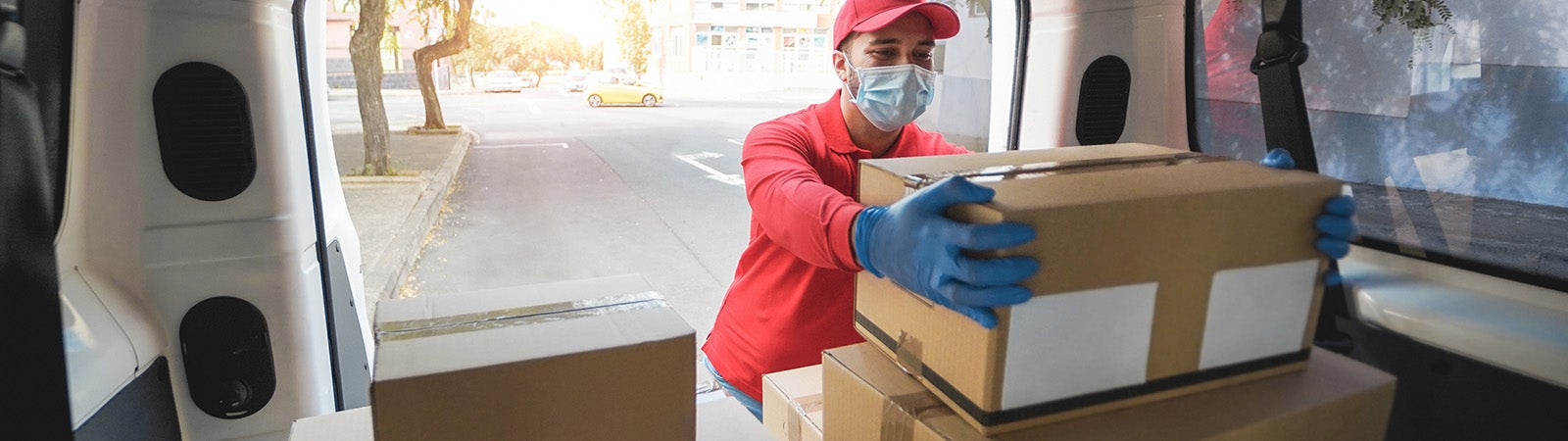 Delivery person picking up box from van