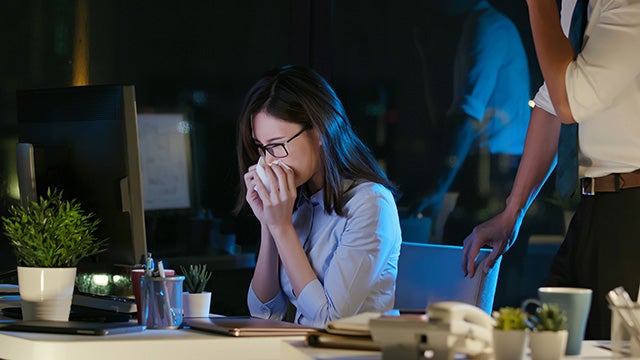Sick worker at desk in office