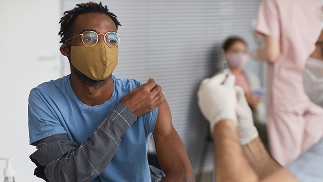 Young Black man receives vaccine
