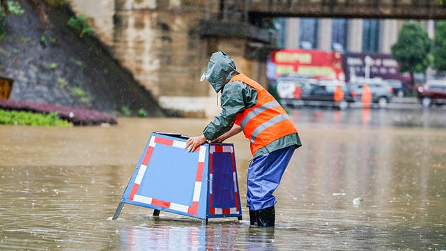 Worker on flooded street